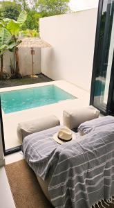 einen Hut auf einem Bett neben einem Pool in der Unterkunft The Banana Tree House in Ban Ta Kun