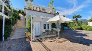 eine Terrasse mit Sonnenschirm und Tisch und Stühlen in der Unterkunft Apartments in Lovran 15143 in Lovran