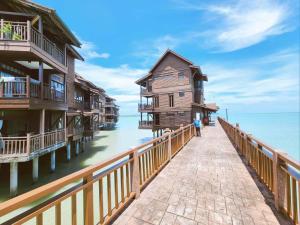 a pier with wooden houses on the water at Sea Villa Langkawi in Kampung Padang Masirat