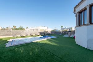 a backyard with a swimming pool and green grass at Cas Fraus in Sa Coma +32 photos