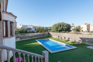 a backyard with a swimming pool and chairs on a lawn at Cas Fraus in Sa Coma