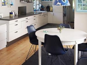 eine Küche mit einem weißen Tisch und schwarzen Stühlen in der Unterkunft Secluded Spa Retreat - By Traum Ferienwohnungen in Lønstrup + 17 Fotos
