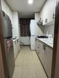 a small kitchen with a refrigerator and a stove at Arisbeth V in Panama City +1 photo
