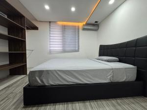 a bedroom with a bed with a black headboard at Arisbeth V in Panama City