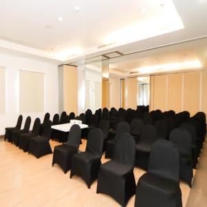 a conference room with black chairs and tables in it at Zest Jemursari by Swiss-Belhotel International in Surabaya