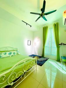 1 dormitorio con cama verde y ventilador de techo en Ddiana 4 Airconds Netflix Wifi, en Alor Setar