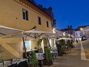 um restaurante ao ar livre com mesas e guarda-sóis à noite em La dimora di Pali em Thiene