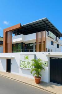 a casa ventura hospital building with a palm tree in front at Costa Verde Hostal in Manta