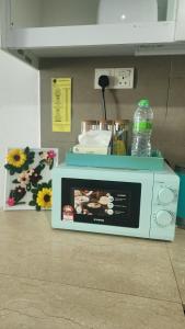 a microwave oven with a bottle of water on top of it at KITA Studio - Kota Bharu City Point in Kota Bharu +16 photos