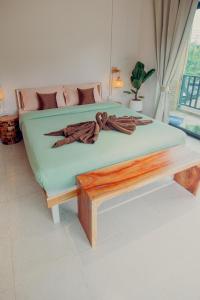 a bedroom with a large bed with a wooden bench at Ark Guesthouse in Pai