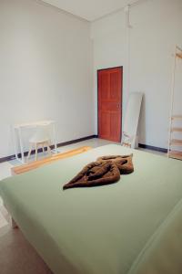 a robe laying on a bed in a room with two chairs at Ark Guesthouse in Pai +29 photos