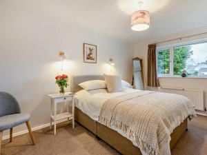 ein Schlafzimmer mit einem Bett und einem Stuhl und einem Fenster in der Unterkunft 3 Bed in Keswick 95858 in Keswick