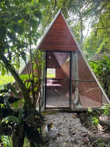 a small house with a window in a garden at Eco Amigo el Rincón in Cerro Punta