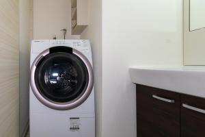 a washing machine in a bathroom next to a sink at Rubens Hakata -ルーベンス博多- in Fukuoka