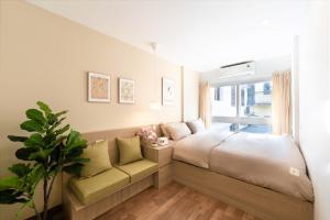 a bedroom with a bed and a couch and a window at Whole House with 3 Bedrooms in Hoan Kiem - 7mins to Hoan Kiem lake - FREE launchdry & breakfast in Hanoi