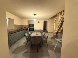 a kitchen with a table and chairs and a staircase at Maison istoriquie in Vescheim