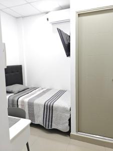 a small bedroom with a bed and a mirror at Habitacion con entrada independiente y aire acondicionado, Centro Piura in Piura