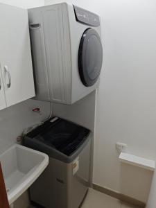 ピウラにあるHabitacion con entrada independiente y aire acondicionado, Centro Piuraのバスルームのゴミ箱の上にぶら下がっているコンピューターモニター