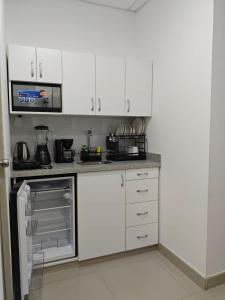 a kitchen with white cabinets and a stove top oven at Habitacion con entrada independiente y aire acondicionado, Centro Piura in Piura