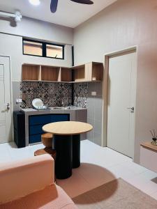 eine Küche mit einem Tisch in der Mitte eines Zimmers in der Unterkunft WiU Cottage, Seri Iskandar in Seri Iskandar