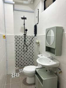 ein Badezimmer mit Toilette, Waschbecken und Spiegel in der Unterkunft WiU Cottage, Seri Iskandar in Seri Iskandar
