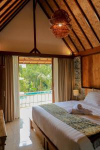 Ένα ή περισσότερα κρεβάτια σε δωμάτιο στο Mina Baturiti Hotel & Resto