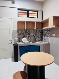 eine Küche mit einem Holztisch und einem runden Tisch in der Unterkunft WiU Cottage, Seri Iskandar in Seri Iskandar + 14 Fotos