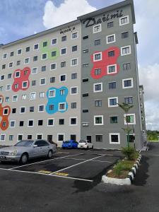 ein großes Gebäude mit bunten Fenstern auf einem Parkplatz in der Unterkunft WiU Cottage, Seri Iskandar in Seri Iskandar