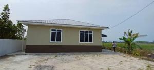 a man standing in front of a small house at d'esaku homestay in Penaga