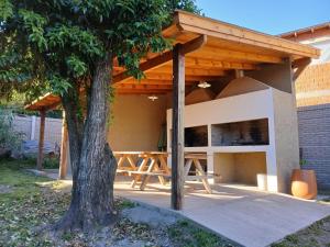 einen Picknicktisch unter einem Pavillon mit einem Baum in der Unterkunft Cabañas y departamentos Sol y Luna in Villa General Belgrano