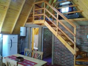 eine Holztreppe in einem Raum mit einer Ziegelwand in der Unterkunft Cabañas y departamentos Sol y Luna in Villa General Belgrano + 10 Fotos