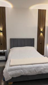 a bed in a bedroom with two lights on the wall at Maison Áurea Loft in Cali