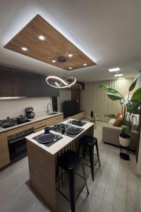 a kitchen with an island with a stove and stools at Lujo y confort en el corazón de Santiago in Santiago +35 photos