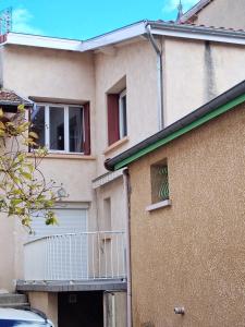 a house with a balcony on the side of it at maison de village in Renaison
