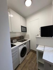 une cuisine avec un lave-linge et un micro-ondes dans l'établissement Appartement chic et moderne au cœur du mythique Marché des Antiquités, à Saint-Ouen