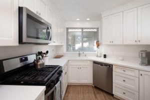 a kitchen with white cabinets and a stove top oven at Blacklake Resort Vacation Rental Nestled on the 9t in Los Berros