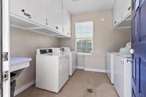 a laundry room with white cabinets and a window at Lagoon View and Ocean Breeze in Oceano