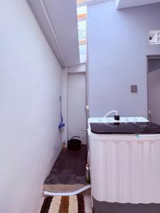 a small room with a sink and a heater at Fortune Homestay Banyuwangi in Banyuwangi
