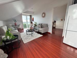 un salon avec un canapé et une table dans l'établissement Belleview Cottage- Cute cottage with views of sea, city and snowpeeks, à Christchurch