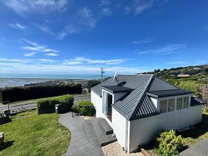 une petite maison blanche avec vue sur l'océan dans l'établissement Belleview Cottage- Cute cottage with views of sea, city and snowpeeks, à Christchurch 26 autres photos