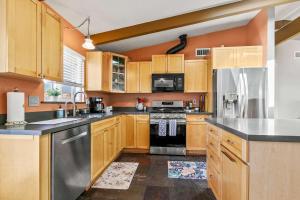 a kitchen with wooden cabinets and stainless steel appliances at The Bay Escape in Cuesta-by-the-Sea +20 photos