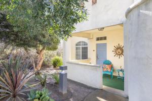 a yellow house with a blue door and a chair at Tide & Treasures in Oceano