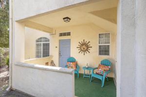 a patio with two chairs and a clock on the wall at Tide & Treasures in Oceano