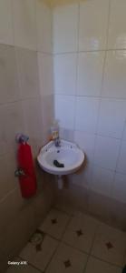 a bathroom with a white sink and a fire extinguisher at Smooth Landing in Ukunda +1 photo