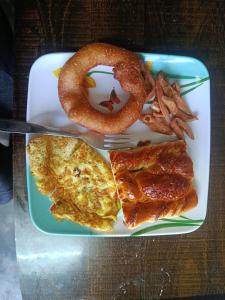 Un plato de desayuno con un pretzel y aros de cebolla. en Manjushree home, en Bhaktapur