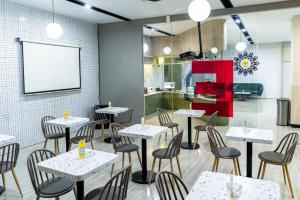 サマリンダにあるYello Hotel Samarindaのテーブルと椅子と黒板のあるレストラン