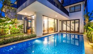 a swimming pool in front of a house at Asri loka villa in Ubud