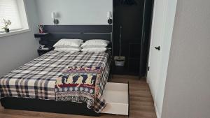 a small bedroom with a bed with a plaid blanket at Mt Spokane ski condo in Mead