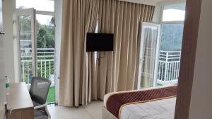 a hotel room with a bed and a balcony at Munnar Peak Paradise in Anachal +17 photos
