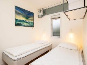 two beds in a room with a painting on the wall at 4 person holiday home on a holiday park in Faaborg in Fåborg